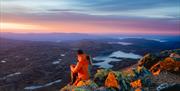 couple sitting on top of  Mount Gausta in the evening sun