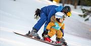 father teaches children to ski
